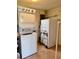 Laundry room with stacked washer and dryer, refrigerator, and shelving at 3023 Maplewood Ave, Lakeland, FL 33803