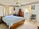 Comfortable main bedroom featuring a ceiling fan, neutral carpet, and a large window with curtains at 3023 Maplewood Ave, Lakeland, FL 33803