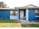 Close-up of the home's front entrance featuring a white front door and an outdoor seating area at 304 Olmo Ct, Winter Haven, FL 33880