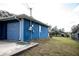 Side view of a single-story home, highlighting the attached garage and a large backyard at 304 Olmo Ct, Winter Haven, FL 33880