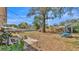 Large, expansive backyard featuring mature trees, a playset, and plenty of space for outdoor activities at 3207 S Polk Ave, Lakeland, FL 33803