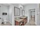 Bathroom with granite countertop, wood cabinets, two mirrors, and toilet at 3224 Pearly Dr, Lakeland, FL 33812