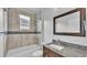 Bathroom featuring granite counters, a bathtub with shower and decorative mosaic tile accents at 3224 Pearly Dr, Lakeland, FL 33812