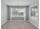 Well-lit dining room featuring gray walls, white trim, a chandelier, and a view of the outside at 3224 Pearly Dr, Lakeland, FL 33812