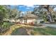 Well-manicured front yard featuring mature trees, green grass, and colorful landscaping beds at 3328 Imperial Ln, Lakeland, FL 33812