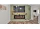 Stylish living room showcasing a fireplace with a television, a decorative shelf, and wood-look flooring at 3328 Imperial Ln, Lakeland, FL 33812