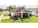 Aerial view of a well-maintained house with a large yard, patio, and a red umbrella at 3882 Rollingsford Cir, Lakeland, FL 33810