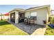 An inviting tiled outdoor patio with a screened-in porch and quaint table set for relaxing in the backyard at 3882 Rollingsford Cir, Lakeland, FL 33810