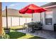 Inviting backyard with a red umbrella, patio seating, and well-maintained lawn at 3882 Rollingsford Cir, Lakeland, FL 33810