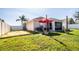 Well-kept backyard with a screened patio, red umbrella, and ample space for outdoor activities and relaxation at 3882 Rollingsford Cir, Lakeland, FL 33810