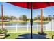 Picturesque backyard view of a pond, white picket fence, and lush landscaping at 3882 Rollingsford Cir, Lakeland, FL 33810