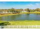 A scenic view of the backyard showing the lake view, landscaping, and fenced in yard at 3882 Rollingsford Cir, Lakeland, FL 33810