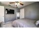 Neutral bedroom featuring a ceiling fan, tv, and large mirror at 3882 Rollingsford Cir, Lakeland, FL 33810