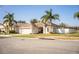 Inviting single-story home with a well-manicured lawn, mature palm trees, and a white picket fence at 3882 Rollingsford Cir, Lakeland, FL 33810