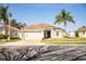 Beautifully landscaped single-story home with a lush lawn, mature trees, and a two-car garage at 3882 Rollingsford Cir, Lakeland, FL 33810