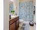 Cozy bathroom featuring a vanity with tile countertop, neutral colored walls and coastal-themed shower curtain at 4010 Winding Vine Dr # 4010, Lakeland, FL 33812