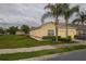 Attractive townhome with a two-car garage, lush landscaping, and mature palm trees at 4010 Winding Vine Dr # 4010, Lakeland, FL 33812