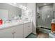 Bright bathroom featuring double sinks, white cabinets, tile flooring and glass enclosed shower at 4010 Winding Vine Dr # 4010, Lakeland, FL 33812