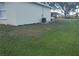 Spacious backyard with lush green grass and landscaping along the house foundation at 406 Fox Lake Dr, Lakeland, FL 33809