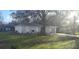 View of the house showing mature trees in the front yard and a glimpse of the neighborhood at 406 Fox Lake Dr, Lakeland, FL 33809