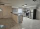 Bright kitchen features gray cabinets, stainless steel appliances, breakfast bar, and light tile flooring at 406 Fox Lake Dr, Lakeland, FL 33809