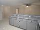 Bright kitchen features gray cabinets, breakfast bar, and light tile flooring at 406 Fox Lake Dr, Lakeland, FL 33809