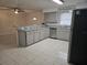 Bright kitchen features gray cabinets, stainless steel appliances, breakfast bar, and light tile flooring at 406 Fox Lake Dr, Lakeland, FL 33809