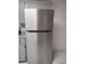 Stainless steel refrigerator next to gray cabinets and granite countertops at 406 Fox Lake Dr, Lakeland, FL 33809