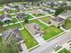 Aerial view of a home with a well-manicured lawn in a community with several homes nearby and a pond at 4688 Hickory Stream Ln, Mulberry, FL 33860