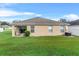 Exterior view of the home from backyard featuring a well-maintained lawn and building details at 4688 Hickory Stream Ln, Mulberry, FL 33860