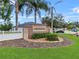 Community entrance with a sign that says 'Creekside,' surrounded by landscaping and palm trees at 4688 Hickory Stream Ln, Mulberry, FL 33860