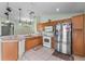 Functional kitchen featuring tile floors, stainless steel appliances, ample counter space, and wooden cabinets at 4688 Hickory Stream Ln, Mulberry, FL 33860