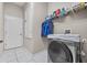 Functional laundry room equipped with a modern washer, storage shelves, and tiled flooring at 4688 Hickory Stream Ln, Mulberry, FL 33860