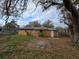 Back of a cozy single-story home featuring a well-kept yard with mature tree and landscaping at 475 W Ethelene St, Bartow, FL 33830