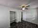 Bedroom featuring dark wood-look floors, ceiling fan, closet with shelves, and a doorway at 475 W Ethelene St, Bartow, FL 33830