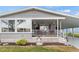 This home has a welcoming front porch featuring decorative plants and an exterior storm window at 4911 Colonnades Club Blvd, Lakeland, FL 33811