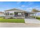 Charming single-story home features a covered carport, front porch, and well-maintained lawn at 4911 Colonnades Club Blvd, Lakeland, FL 33811