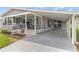 Exterior view of a home with a covered carport, front porch with seating, and neat landscaping at 4911 Colonnades Club Blvd, Lakeland, FL 33811