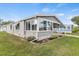 Charming gray home featuring a sunroom with large windows and a covered porch at 4911 Colonnades Club Blvd, Lakeland, FL 33811