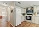 Compact kitchen with white cabinetry, modern appliances, and wood-look flooring at 4911 Colonnades Club Blvd, Lakeland, FL 33811