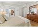 Bedroom showing wood floors, a dresser with mirror, and view into the bathroom at 4911 Colonnades Club Blvd, Lakeland, FL 33811