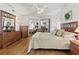 Bedroom features wood floors, a ceiling fan, and a decorative mirror on the dresser at 4911 Colonnades Club Blvd, Lakeland, FL 33811