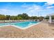 Large community pool surrounded by brick paving, lounge chairs, and white fencing at 4911 Colonnades Club Blvd, Lakeland, FL 33811