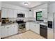 Bright kitchen with clean white cabinets, stainless steel appliances, and a tile floor at 507 8Th Se St, Fort Meade, FL 33841