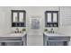 Charming bathroom featuring double vanities, marble countertops, dark cabinetry, and a window offering natural light at 511 Mcrorie St, Lakeland, FL 33803