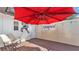 Cozy outdoor patio with a red umbrella, chair, and privacy fence at 511 Mcrorie St, Lakeland, FL 33803