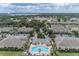 Aerial view of the community featuring a central pool, lush landscaping, and nearby lake at 5377 Quarry Rock Rd, Lakeland, FL 33809