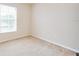 Neutral carpeted bedroom with bright natural light streaming in through a large window at 5377 Quarry Rock Rd, Lakeland, FL 33809