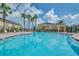 Community pool area with blue water, lounge chairs and palm trees under a sunny sky at 5377 Quarry Rock Rd, Lakeland, FL 33809