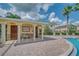 Exterior of pool house with stone accent columns near the community swimming pool and sun loungers at 5377 Quarry Rock Rd, Lakeland, FL 33809